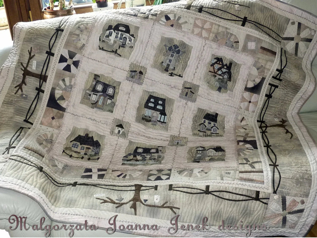 Handmade patchwork quilt showcasing vintage buildings in muted gray tones, perfect for cozy home decor.