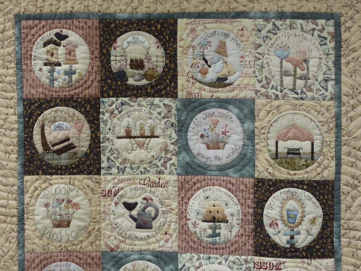 Quilt featuring floral and garden-themed patches in soft pastels, crafted from cotton fabric.