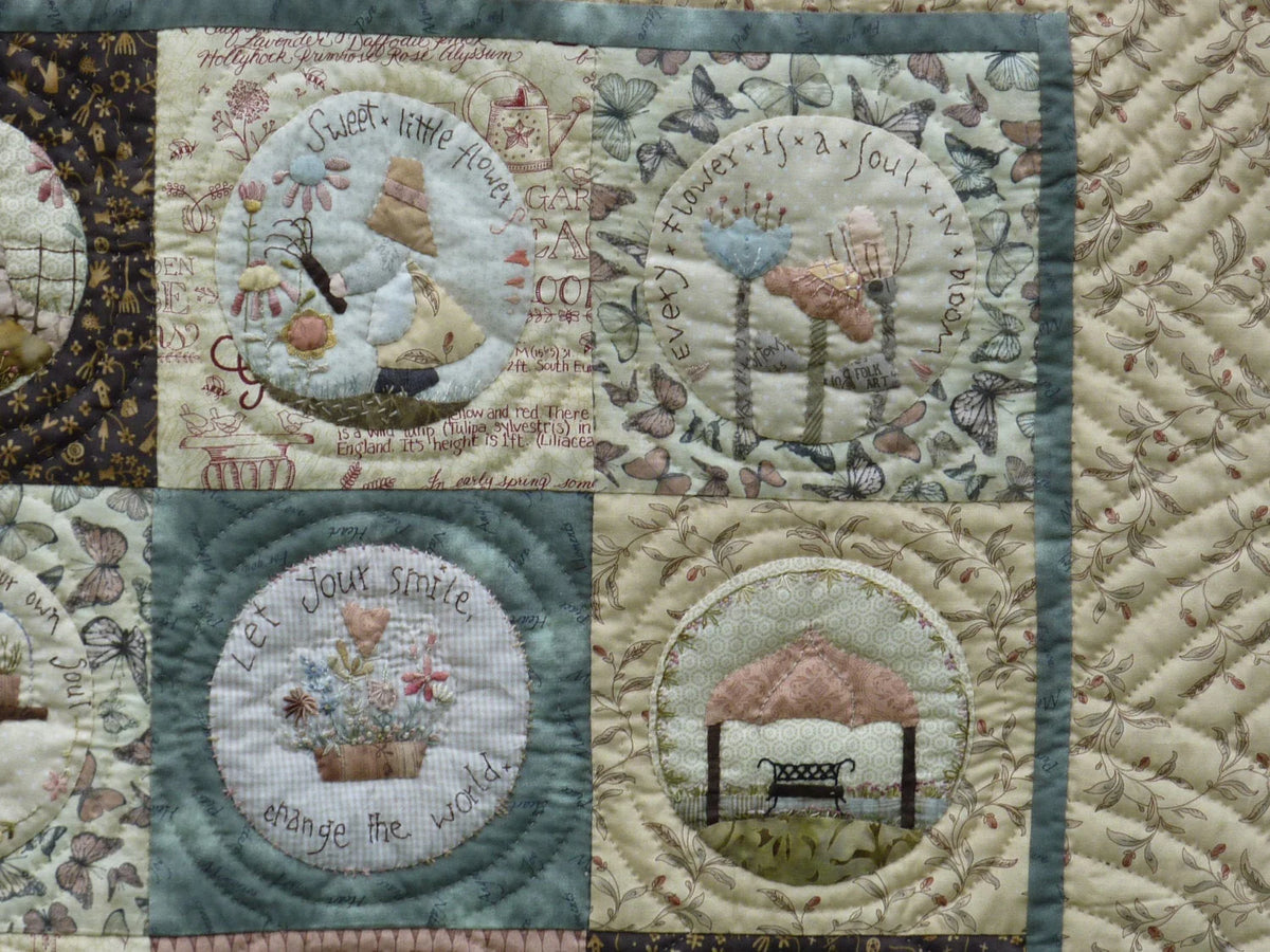 Colorful quilt featuring floral designs, pastel colors, and inspirational quotes on soft fabric.