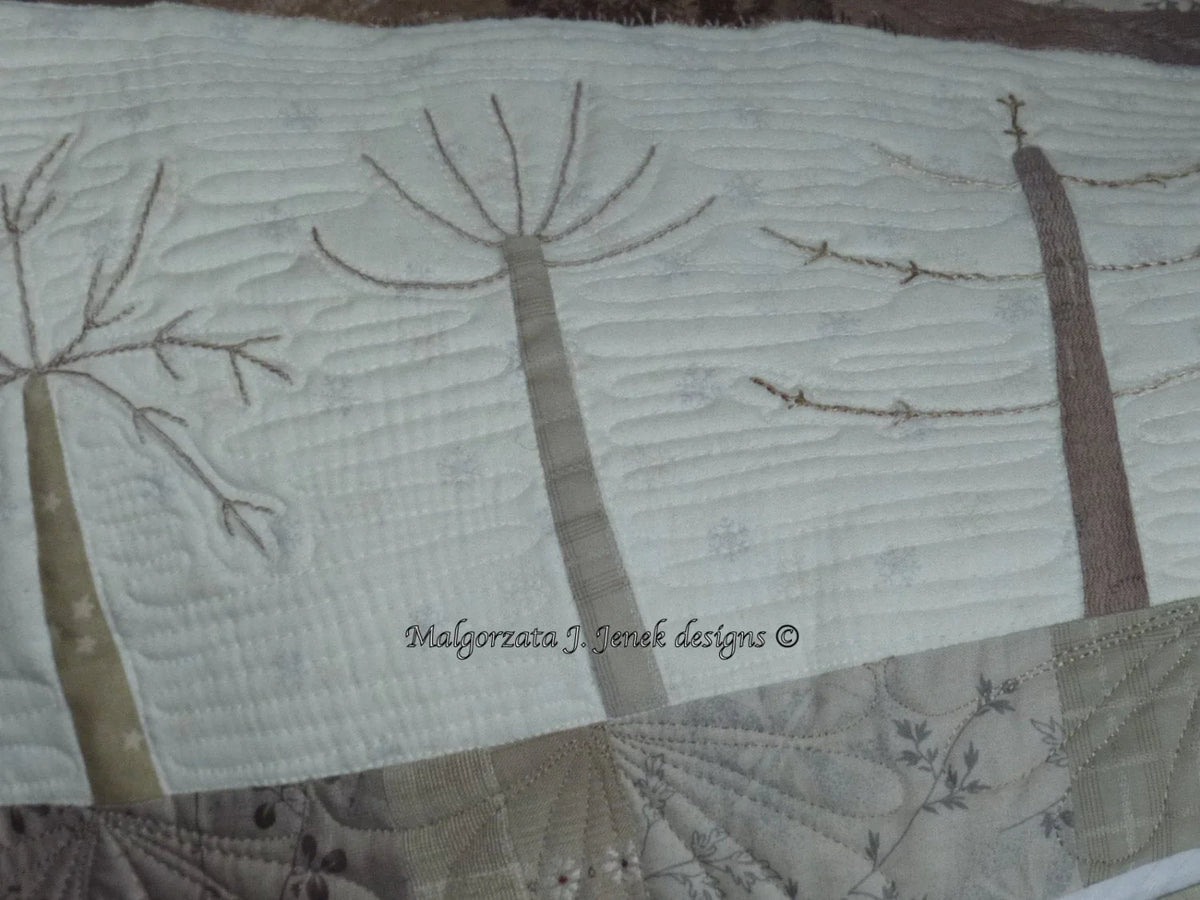Quilt featuring abstract tree designs, beige and cream colors, intricate stitching, and soft cotton material.