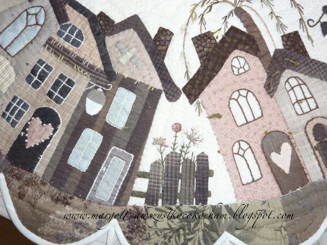 Colorful patchwork design featuring whimsical houses, floral details, and a cozy aesthetic.