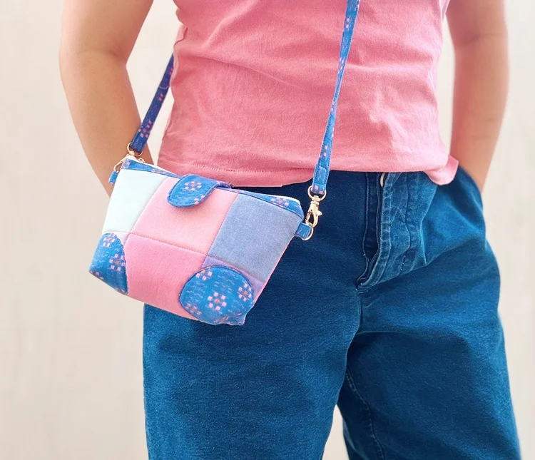 Colorful patchwork crossbody bag in pastel shades, featuring secure strap and soft material.