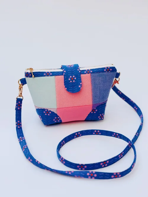 Multicolored patchwork crossbody bag in denim with zip closure and adjustable strap.