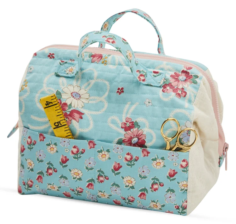 Blue floral quilting supplies bag with pockets, measuring tape, and scissors, perfect for sewing projects.