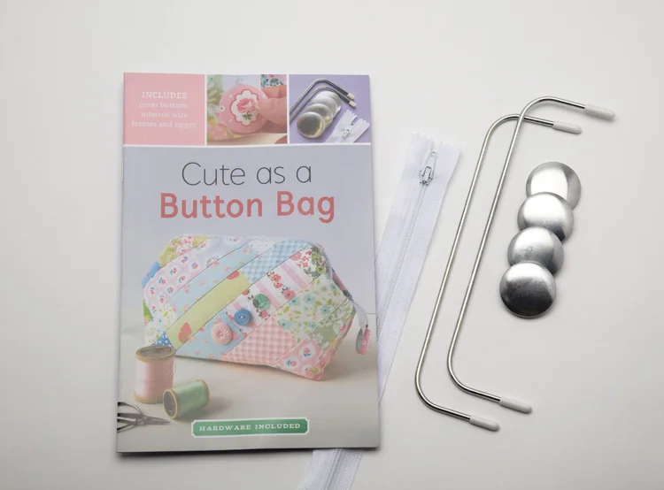 'Cute as a Button Bag' sewing pattern book with hardware, featuring colorful patchwork design, zipper, and frame.