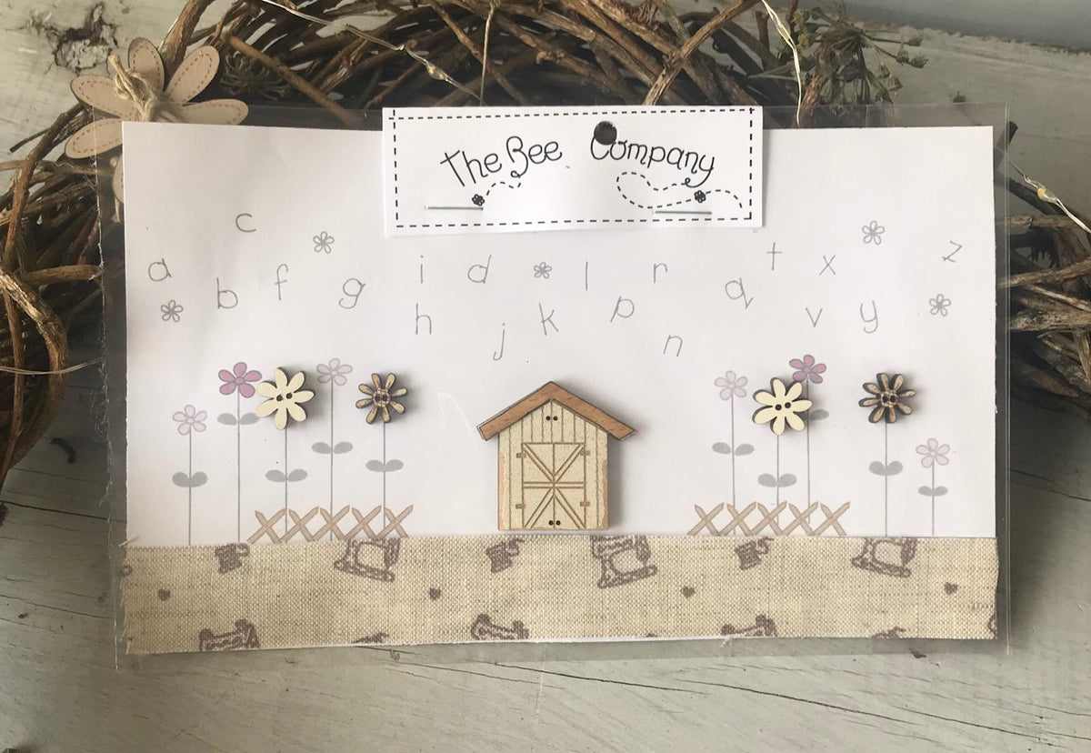Charming decorative card featuring wooden flower embellishments and a barn design, ideal for crafting.