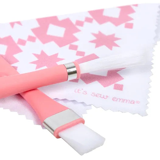 It's Sew Emma pink fabric cutting tools with two brushes and patterned design cloth for sewing projects.