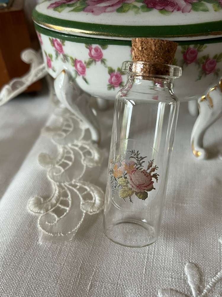Clear glass bottle with floral design and cork stopper, ideal for crafts and decorative use.