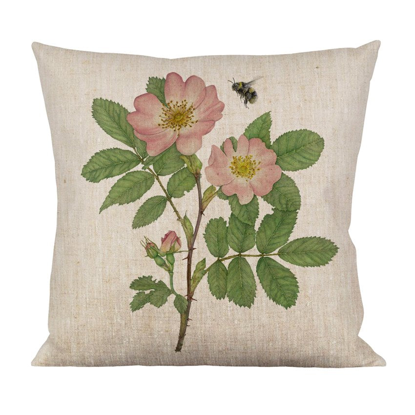 Floral decorative throw pillow featuring pink roses and leaves on a textured beige background.