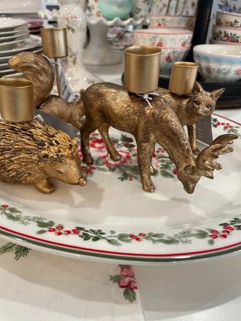 Set of three gold animal candle holders: hedgehog, deer, and fox on a decorative plate.